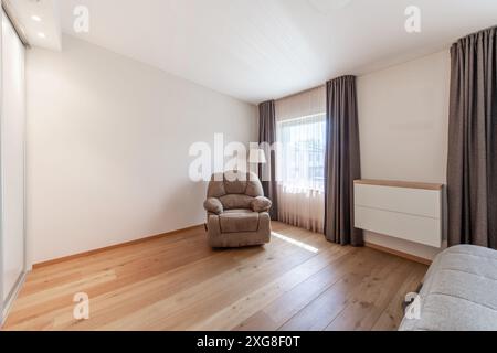 Interni lussuosi della camera da letto principale, casa moderna, splendidi interni, ampia camera da letto. Cassettiera sullo sfondo. Poltrona. Grandangolo Foto Stock