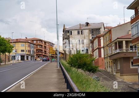 Astorga, Spagna - 3 giugno 2023: Una strada ad Astorga, Spagna, con un mix di edifici vecchi e nuovi, con un'auto che passa sulla strada. Foto Stock