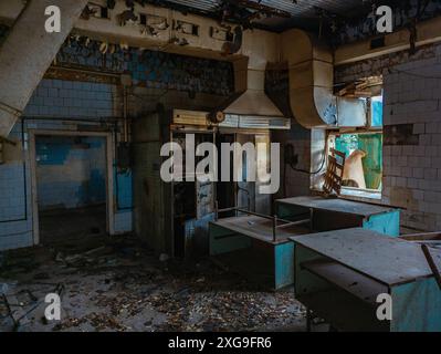 Cucina abbandonata e rovinata di mensa o ristorante di fabbrica chiuso. Foto Stock