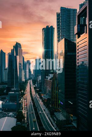 Giacarta, Indonesia - 12 maggio 2024. Questa foto cattura il paesaggio urbano di Giacarta immerso nel caldo bagliore di un tramonto. Foto Stock