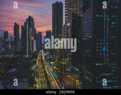 Giacarta, Indonesia - 12 maggio 2024. Questa foto cattura il dinamico paesaggio urbano di Giacarta al crepuscolo. I moderni grattacieli raggiungono il cielo, il loro vento Foto Stock