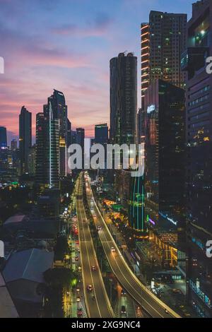 Giacarta, Indonesia - 12 maggio 2024. Questa foto cattura il dinamico paesaggio urbano di Giacarta al crepuscolo. I moderni grattacieli raggiungono il cielo, il loro vento Foto Stock