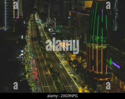 Giacarta, Indonesia - 12 maggio 2024. Questa foto offre una vista dall'alto di una trafficata autostrada di Giacarta di notte. L'autostrada è un tortuoso nastro di rosso e. Foto Stock