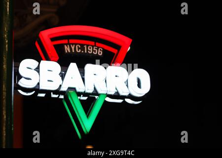 Insegna illuminata per il New York Pizza Sbarro di notte Foto Stock