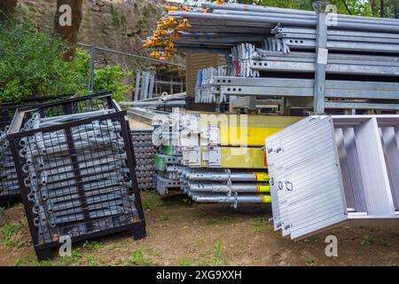 Pali per ponteggi e staffe impilati in un cortile. Ponteggio con telaio giapponese. Foto Stock