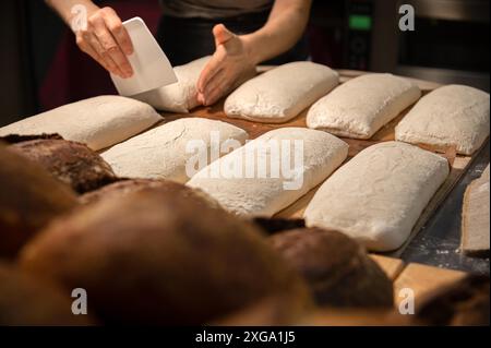 Primo piano della pasta per impastare con le mani femminili per preparare pane artigianale in panetteria domestica Foto Stock