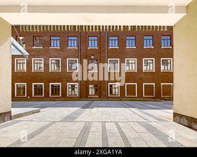 cortile di un vecchio edificio industriale ristrutturato. vista dall'arco del passaggio pedonale. Foto Stock