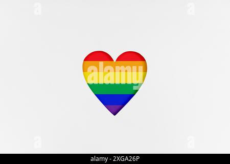 Forma a cuore con nuova bandiera di orgoglio LGBTQ ridisegnata su cartone bianco. Cartone stampato a forma di cuore fustellato. Vista dall'alto Foto Stock