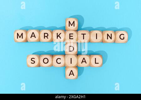 Social Media Marketing parole su blocchi di legno su sfondo blu. Vista dall'alto Foto Stock