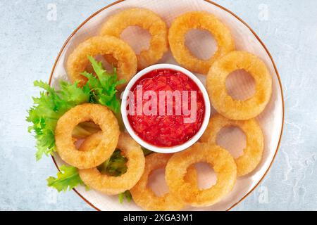 Anelli Calamari primo piano. Anelli di calamari fritti profondi su un piatto, sparati dalla parte superiore Foto Stock