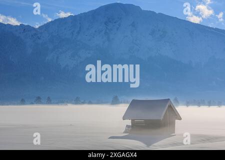 Capanna in legno di fronte alle montagne, inverno, Loisach-Kochelsee-Moor, vista Jochberg, Baviera, Germania, Europa Foto Stock