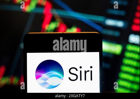 In questa immagine, l'assistente digitale di proprietà di Apple, Siri, logo visualizzato su uno smartphone con un grafico indice di borsa economica sullo sfondo. Foto Stock
