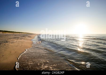 Splendida e ampia spiaggia al tramonto sul Mar Baltico. Cielo limpido e nuvoloso. Dune e foresta. Slajszewo, Choczewo, Polonia. Foto Stock