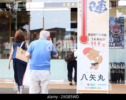 Tokyo, Giappone. 8 luglio 2024. Gli acquirenti passano davanti a un grande termometro che viene esposto presso il grande magazzino Yagihashi a Kumagaya, nella periferia di Tokyo, mentre la temperatura di Kumagaya è salita di 35 gradi Celsius lunedì 8 luglio 2024. (Foto di Yoshio Tsunoda/AFLO) Foto Stock