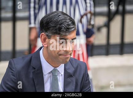 Rishi Sunak deputato parlò a Downing Street con sua moglie, Ahshata Murty, dietro di lui nel suo ultimo giorno come primo ministro il giorno dopo che i laburisti ottennero il gen Foto Stock