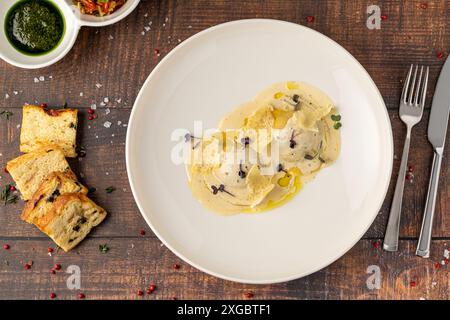 Ravioli di formaggio con salse su un piatto di porcellana bianca Foto Stock