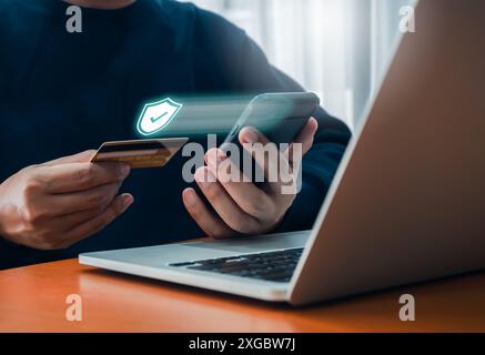 Concetto di pagamento sicuro. L'icona dello scudo di sicurezza, l'ologramma appare mentre un uomo d'affari utilizza l'acquisto di smartphone con carta di credito in mano per pagare, Foto Stock