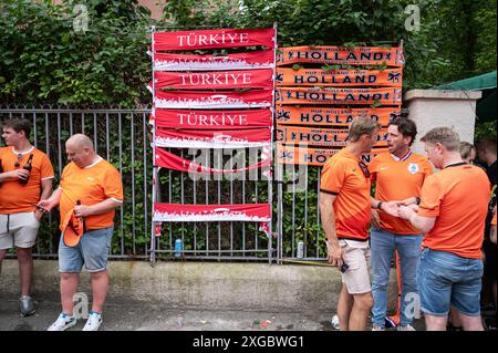 06.07.2024, Berlino, Germania, Europa - i tifosi della nazionale olandese si trovano di fronte a un venditore ambulante che vende sciarpe per tifosi. Foto Stock