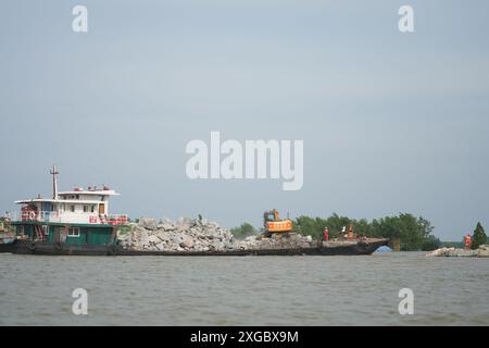 Huarong, la provincia cinese di Hunan. 8 luglio 2024. I soccorritori lavorano per bloccare la breccia di dighe nel lago Dongting nella contea di Huarong, nella provincia di Hunan della Cina centrale, 8 luglio 2024. A partire da lunedì pomeriggio, 180,5 metri della breccia di 226 metri nella diga erano stati sigillati, secondo il quartier generale del controllo delle inondazioni e della siccità di Yueyang. Crediti: Xue Yuge/Xinhua/Alamy Live News Foto Stock