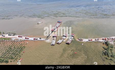 Huarong, la provincia cinese di Hunan. 8 luglio 2024. Una foto aerea mostra i soccorritori che lavorano per bloccare la breccia di dighe nel lago Dongting nella contea di Huarong, nella provincia di Hunan della Cina centrale, 8 luglio 2024. A partire da lunedì pomeriggio, 180,5 metri della breccia di 226 metri nella diga erano stati sigillati, secondo il quartier generale del controllo delle inondazioni e della siccità di Yueyang. Crediti: Chen Zhenhai/Xinhua/Alamy Live News Foto Stock