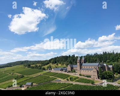 9 luglio 2024, Assia, Rüdesheim am Rhein: Solo alcune nuvole bianche si spostano attraverso il cielo altrimenti blu sopra l'abbazia di S. Hildegard nel Rheingau (vista aerea con un drone). Il tempo dovrebbe continuare a mostrare il suo lato estivo nei prossimi giorni. Foto: Boris Roessler/dpa Foto Stock