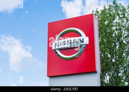 Telford, Regno Unito - 8 luglio 2024: Logo e nome della società automobilistica Nissan fuori dallo showroom di una concessionaria Foto Stock