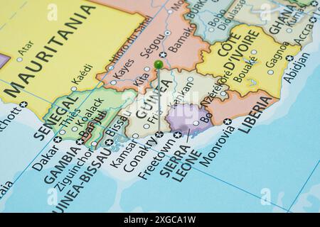 Avvicinati a una città di Conarkry con un ago di spillo verde sulla mappa politica del paese della Guinea Foto Stock