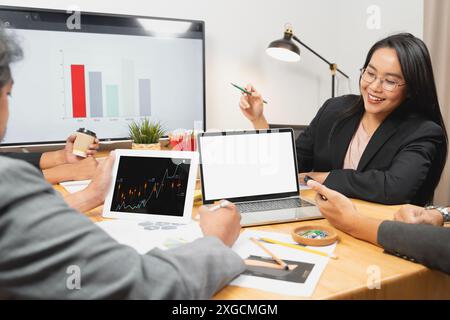 Professionisti aziendali. Analisi di dati nuovi. Gruppo di giovani imprenditori fiduciosi che discutono di un nuovo progetto e sorridono mentre trascorrono del tempo nella sala operatoria Foto Stock