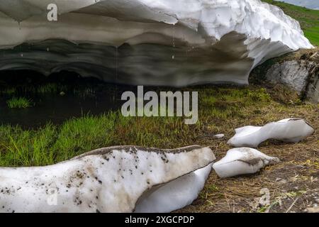 Riposo dalla valanga, neve sciolta nelle Alpi del Vorarlberg fare tunnel nella valanga, neve sulle montagne si scioglie, campi di neve su pendii ripidi Foto Stock