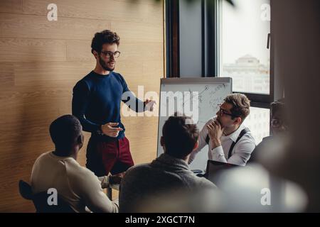 Caucasian team building coach maschio rispondendo alle domande che il pubblico multietnico chiedere durante il seminario di business Foto Stock