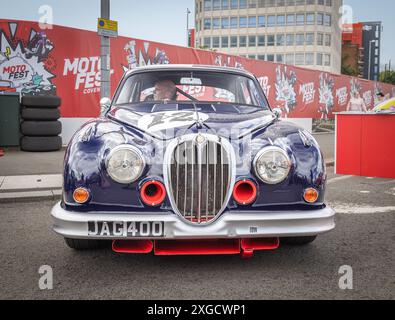 Vista frontale di una Jaguar MK2 parcheggiata in un ambiente urbano durante il Coventry Motofest. Foto Stock