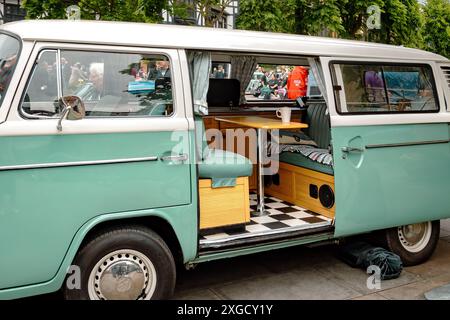 Vista laterale di un camper Volkswagen d'epoca con la porta laterale scorrevole aperta. Camper VW, viaggio su strada, viaggio o concetto di stile di vita alternativo. Foto Stock