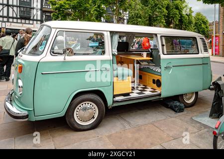 Vista laterale di un camper Volkswagen d'epoca con la porta laterale scorrevole aperta. Camper VW, viaggio su strada, viaggio o concetto di stile di vita alternativo. Foto Stock