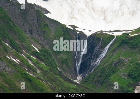 Cascata, neve che si scioglie nelle Alpi del Vorarlberg, neve sulle montagne che si fonde e cade in torrenti e cascate nella valle, campi di neve Foto Stock