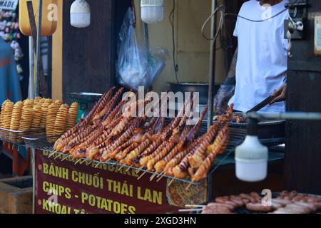 Un mercato che vende cibo di strada vietnamita come calamari alla griglia, rane alla griglia, carne alla griglia e okra nel mercato notturno della città vecchia di Hoi An Foto Stock