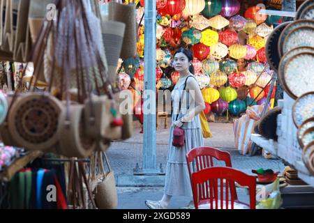 La ragazza fa una passeggiata tra la stalla della luce della lanterna nel mercato notturno della città vecchia di Hoi An, in vietnam Foto Stock