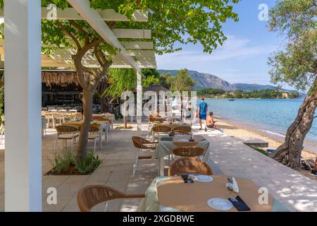 Vista della cena all'aperto presso la spiaggia di Dassia e il Mar Ionio, Dassia, Corfù, Mar Ionio, Isole greche, Grecia, Europa Foto Stock