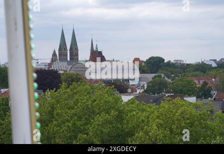 Blick aus einem Riesenrad auf die Bremer Domtürme. Rechts daneben das ehemalige Polizeihaus, davor die sogenannte Pierwoß-tonne, ein Dachaufbau für das Theater am Goetheplatz, der in der Amtszeit des Intendanten Klaus Pierwoß errichtet wurde und unter anderem Probebühnen beherbergt. DAS Riesenrad, das diesen Blick ermöglicht, stand Anfang Juli 2024 auf dem Gelände des Freiluftfestivals Breminale im Bremer Ostertorviertel. *** Vista delle torri della cattedrale di Bremens da una ruota panoramica accanto ad essa sulla destra si trova l'ex stazione di polizia, di fronte ad essa la cosiddetta Pierwoß tonne, una struttura del tetto per Foto Stock