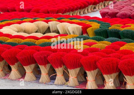 Vivaci e colorati bastoncini di incenso disposti a terra per asciugare al sole a Quang Phu Cau, Ung Hoa, Vietnam del Nord, Asia a giugno - rosso, giallo, verde Foto Stock