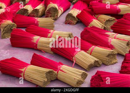 Fasci di incenso rosso vibrante disposti a terra per asciugare al sole a Quang Phu Cau, Ung Hoa, Vietnam del Nord, Asia a giugno - bastoncini di incenso rossi Foto Stock