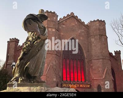 Una scultura di Roger Conant, il fondatore della città, si trova di fronte al Museo delle streghe di Salem, che illustra i processi alle streghe nella storia della città Foto Stock