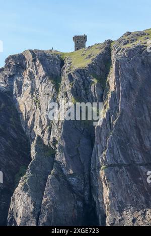 Torre napoleonica sulla scogliera marina irlandese con uomo sul promontorio costiero di Carrigan Head, contea di Donegal, Irlanda. Foto Stock