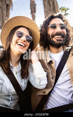 Felici giovani amici seduti sul retro della cabriolet che si divertono durante il viaggio Foto Stock