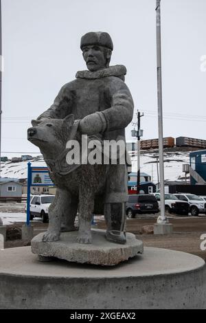 Scultura in pietra di un uomo e un cane Inuit nell'edificio RCMP sulla Federal Road a Iqaluit, Nunavut, Canada Foto Stock