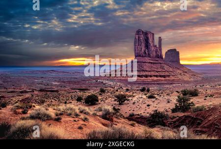 A sunset view of Monument Valley in Arizona with dramatic clouds and rock formations Foto Stock