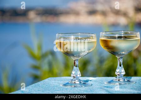 Spumante freddo, cava o champagne in due bicchieri da coupé sul tavolo con vista mare vicino a Mentone e Monte Carlo, Costa Azzurra, la Francia è estate Foto Stock