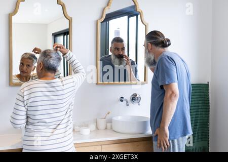Il bagno era arredato con cura, la coppia anziana era in piedi davanti agli specchi Foto Stock