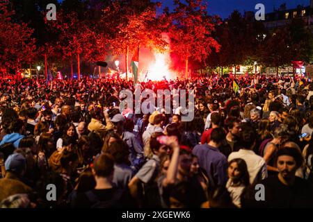 La gente celebra la vittoria del Nouveau Front Populaire al secondo turno delle elezioni legislative francesi a Place Stalingrad. Dopo aver perso il primo turno delle elezioni legislative francesi, la coalizione di sinistra Nouveau Front Populaire ha vinto il secondo turno. Migliaia di persone scesero in strada e celebrarono in Place Stalingrad, fuori dalla sede di la France Insoumise, con discorsi di diverse personalità del partito. Un altro momento culminante dei festeggiamenti è stata, inevitabilmente, la Place de République, con diversi registri di scontri tra polizia e manifestanti. Foto Stock