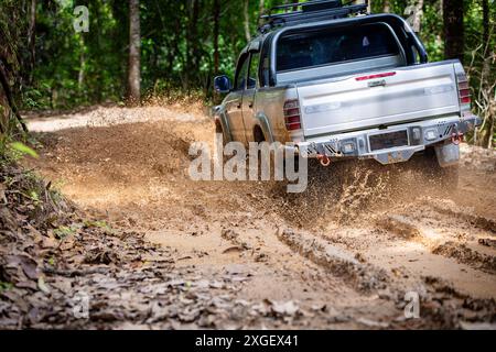 Auto che corrono su strade fuoristrada e che spruzzano fango su sentieri naturali. Guida fuoristrada su strade fangose. SUV fuoristrada 4x4 cavalca tra fangose pozzanghere, fuoristrada Foto Stock