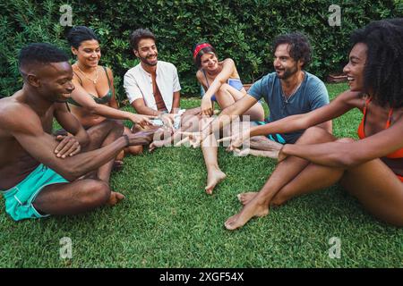 Gruppo di amici che suonano forbici di carta rock - godersi una divertente attività all' aperto - gruppo diversificato ridendo e sorridendo - atmosfera rilassata e gioiosa - Foto Stock